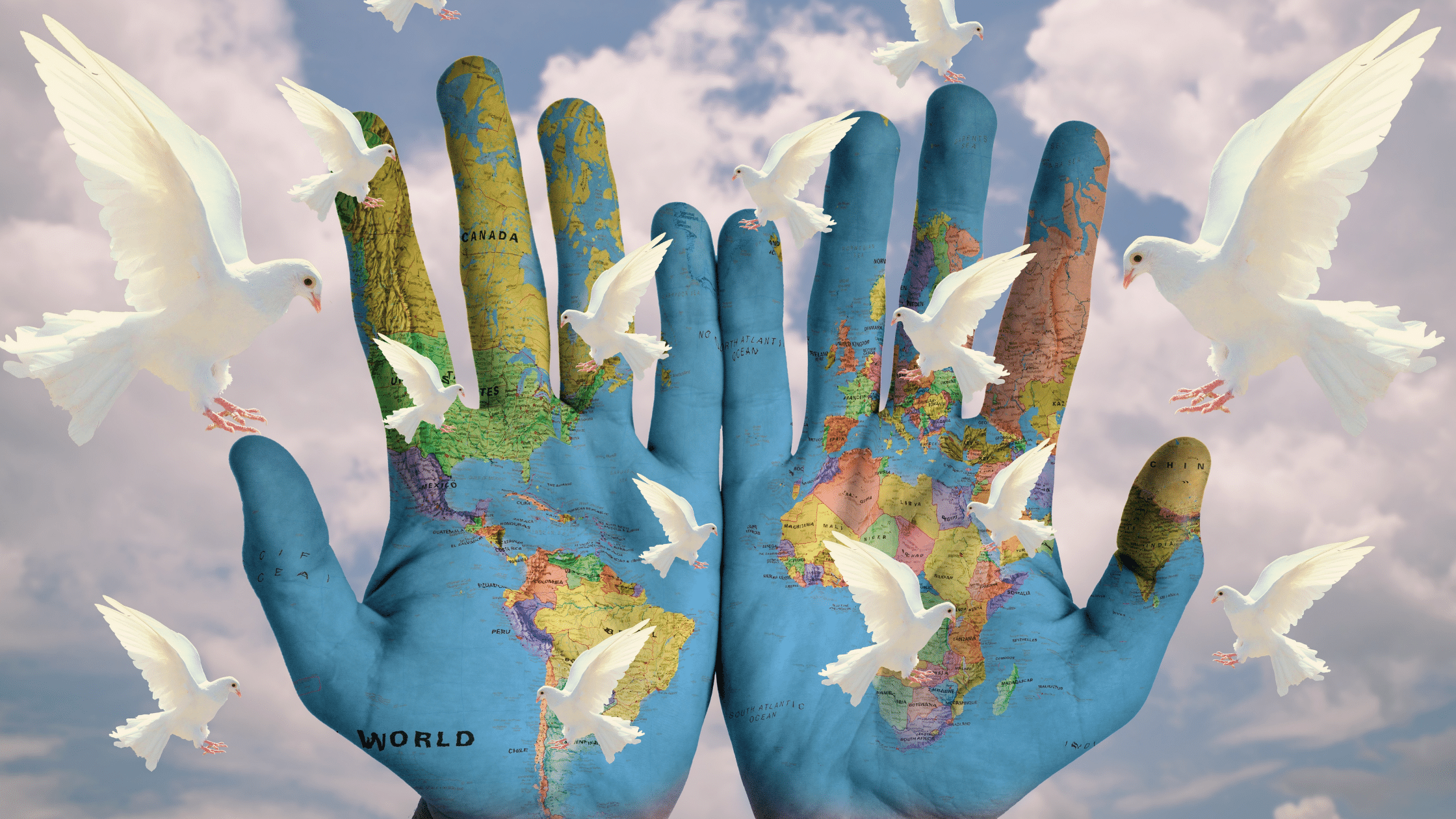 Twee handen beschilderd met de wereldkaart witte duiven vliegen erom heen