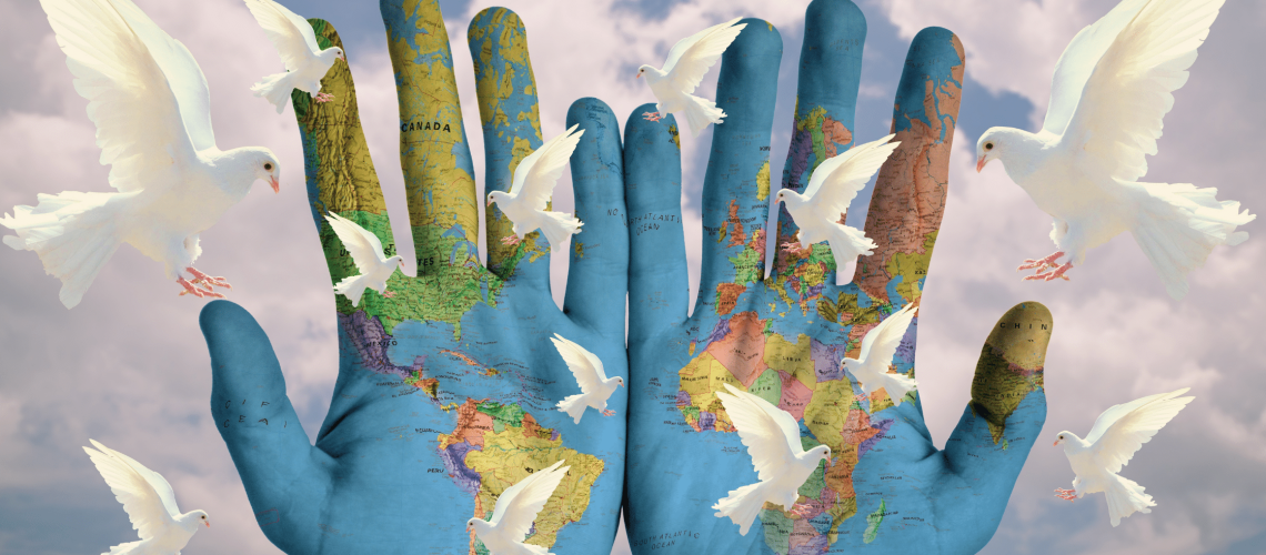 Twee handen beschilderd met de wereldkaart witte duiven vliegen erom heen